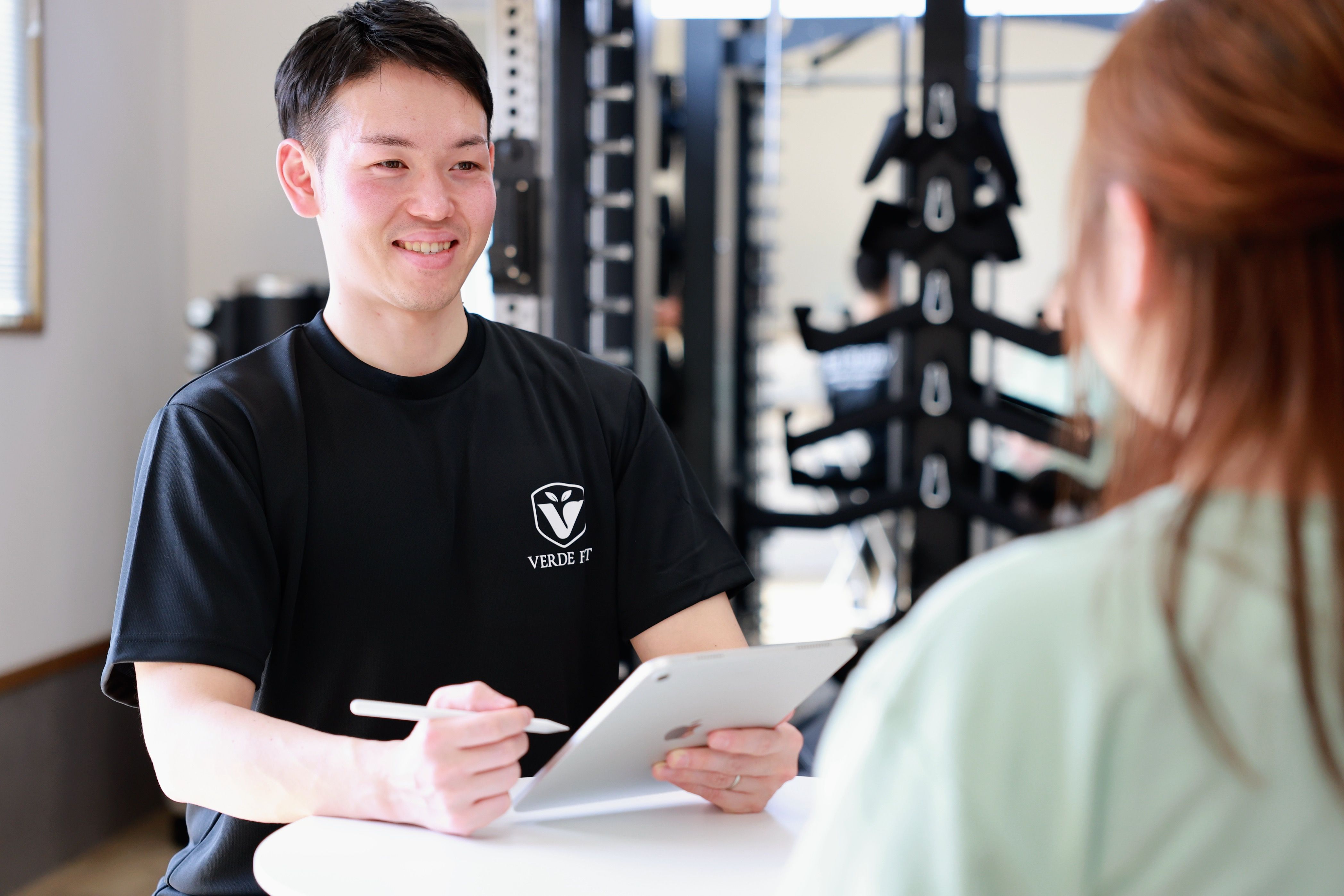 横手市VERDEFITのコーチングセッションでトレーナーが笑顔でサポートする様子