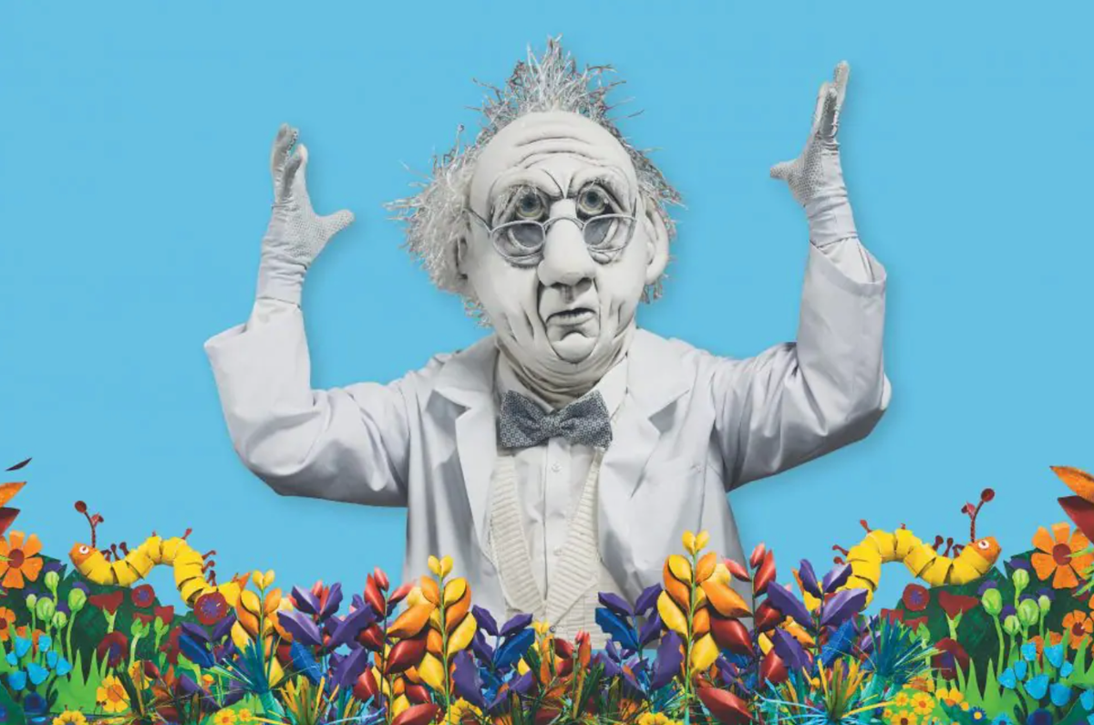 This graphic image is of a completely white elderly puppet man which a very large head and glasses. He is in front of a sky blue background and along the bottom of the graphic is an array of flower like designs, multicoloured with two yellow caterpillars