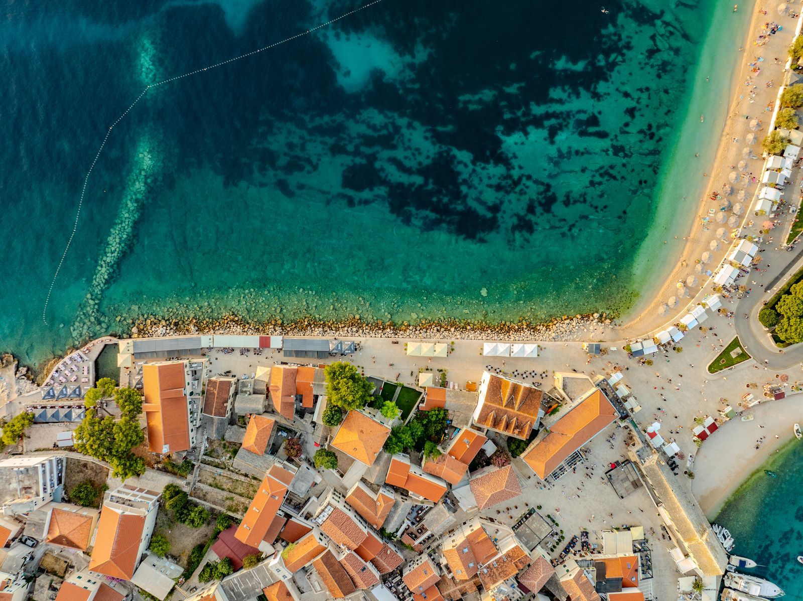 Aerial view of a Mediterranean coastal town beside a turquoise lagoon