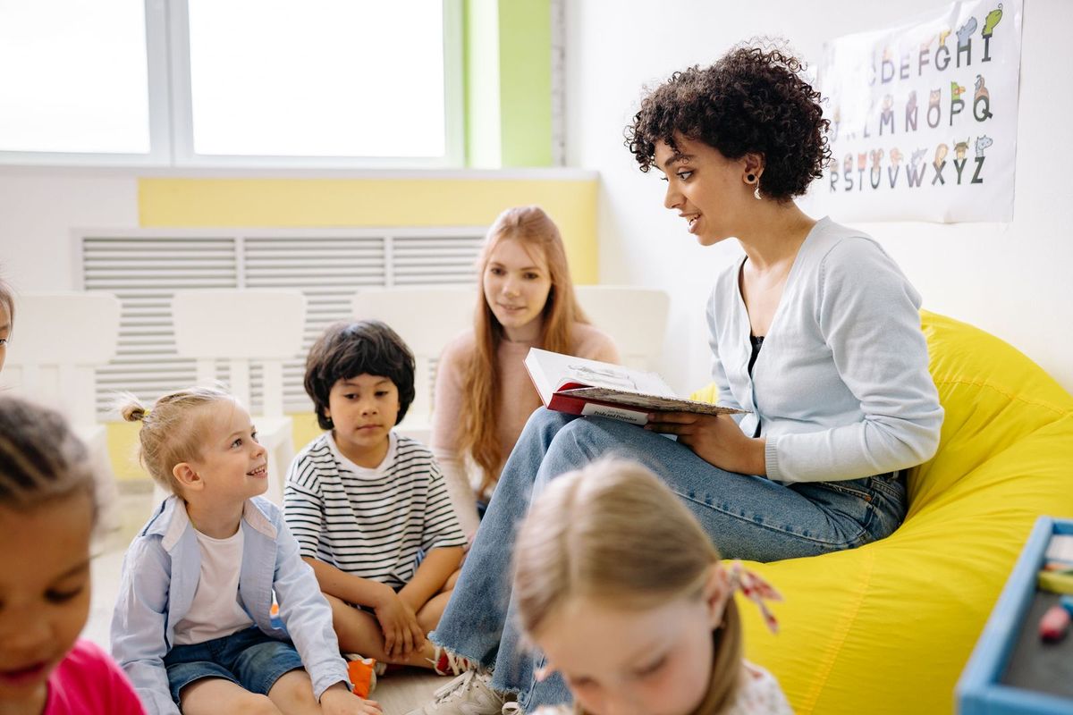 Teacher reading with young children in a bright classroom