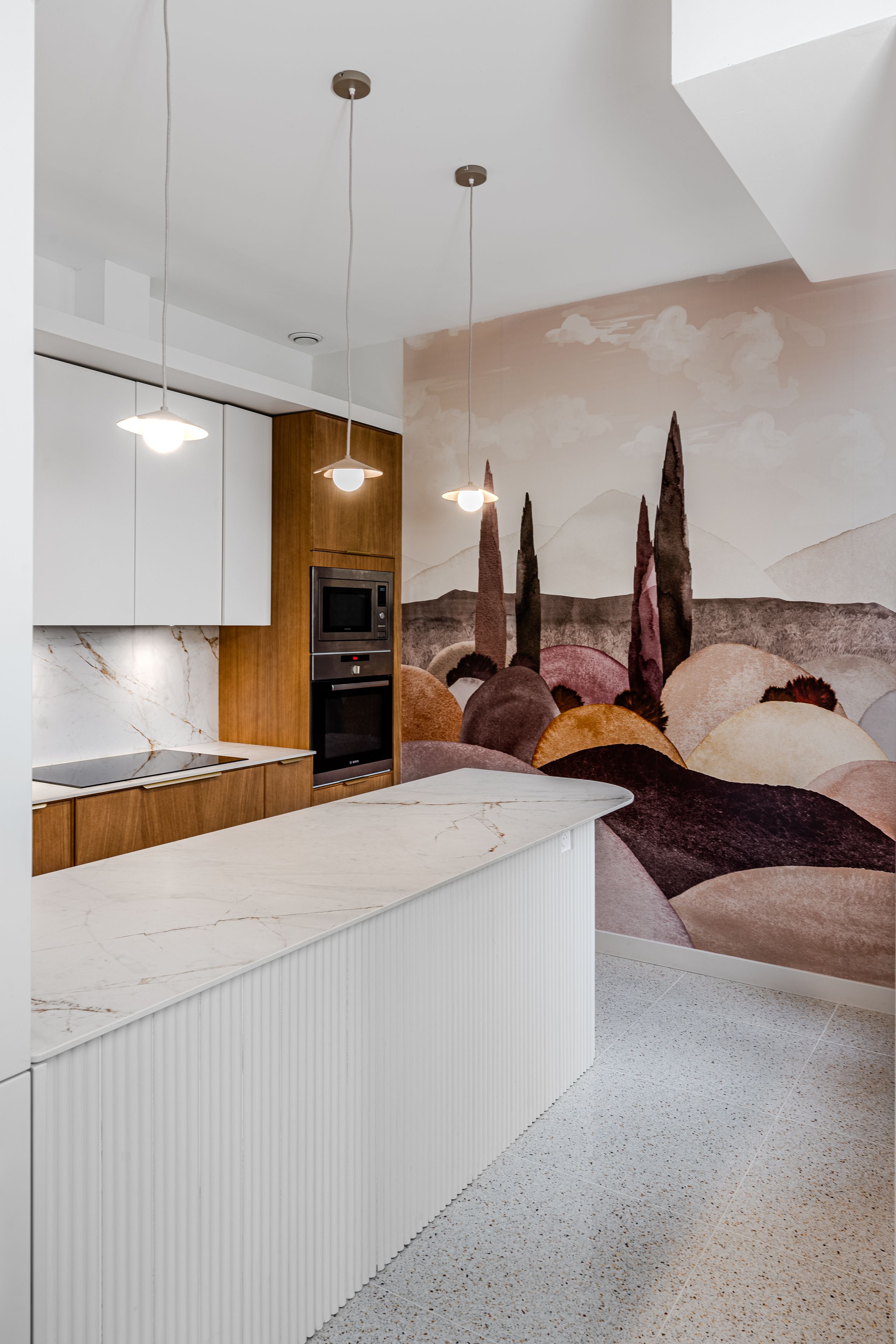 Rénovation d’une cuisine à Pessac avec rangements intégrés et claustra arrondi.