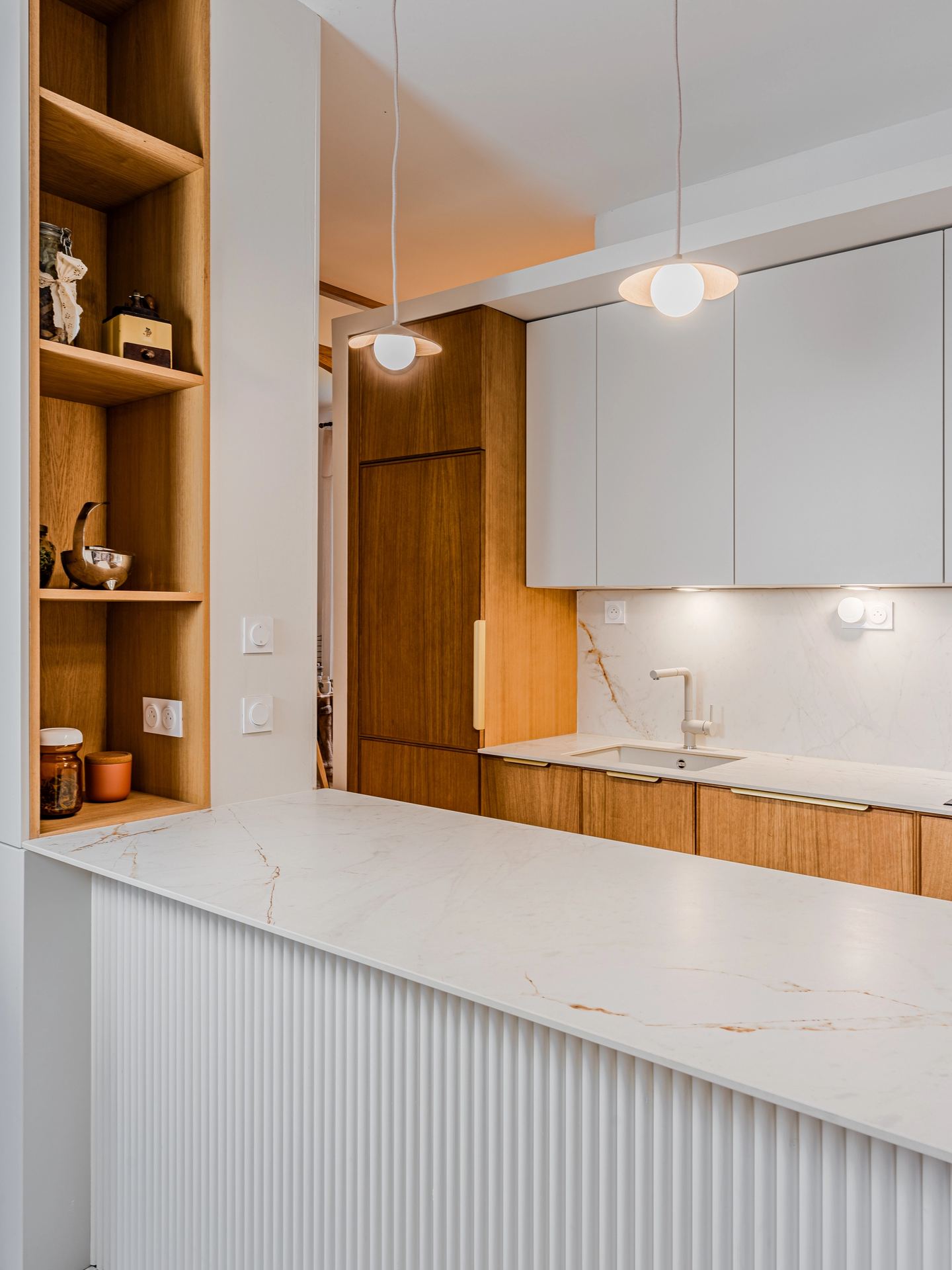 Rénovation d’une cuisine à Pessac avec rangements intégrés et claustra arrondi.