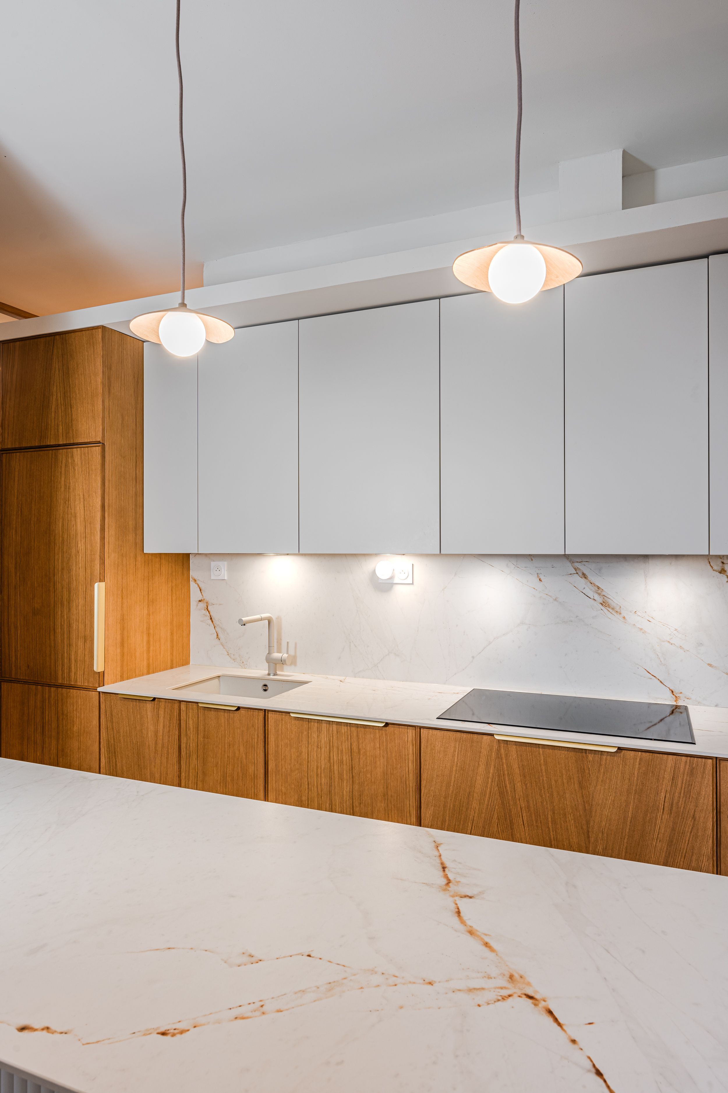 Rénovation d’une cuisine à Pessac avec rangements intégrés et claustra arrondi.