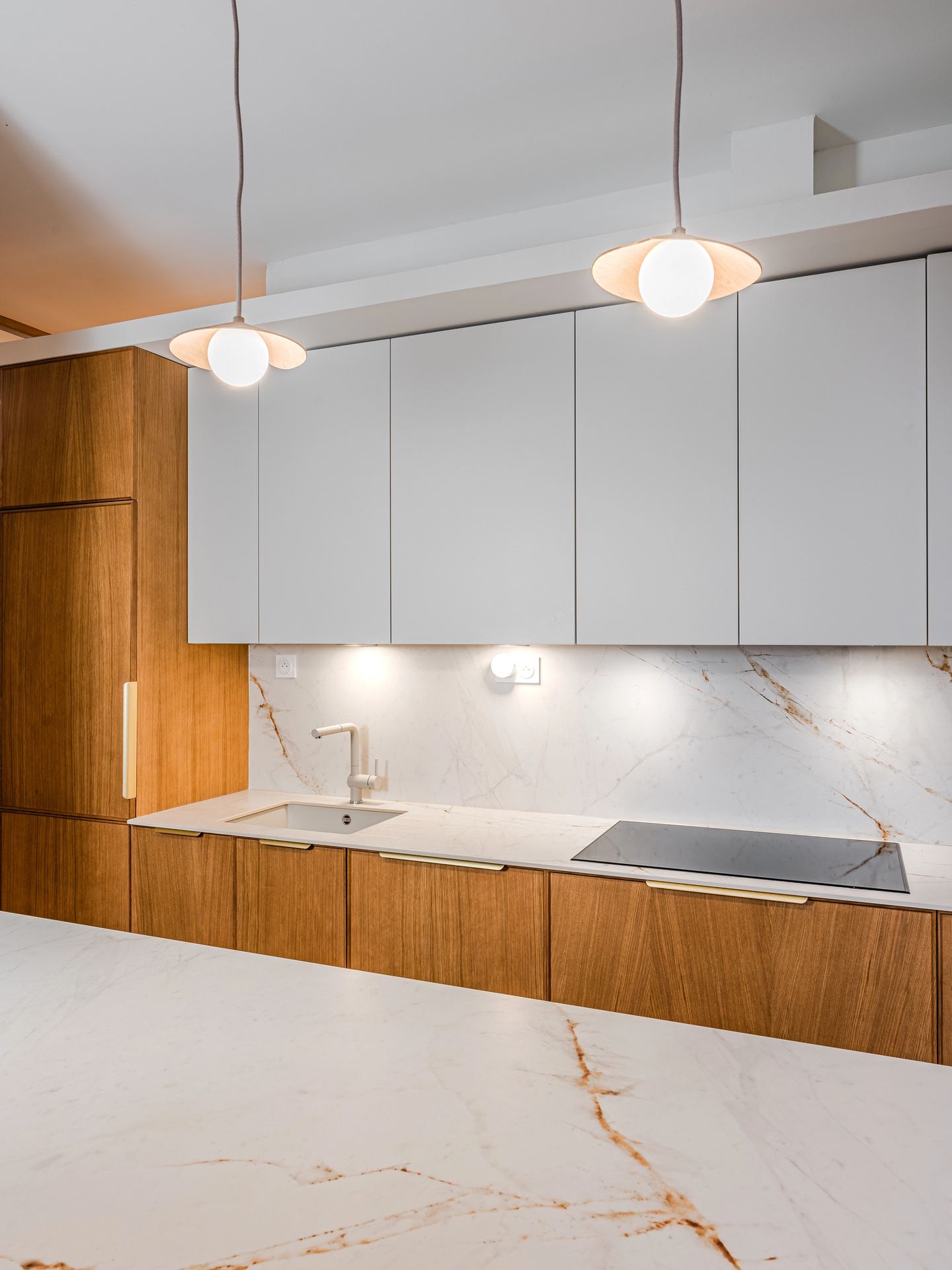 Rénovation d’une cuisine à Pessac avec rangements intégrés et claustra arrondi.