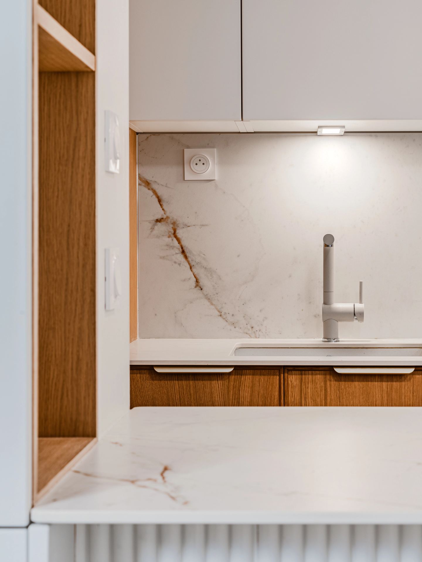 Rénovation d’une cuisine à Pessac avec rangements intégrés et claustra arrondi.