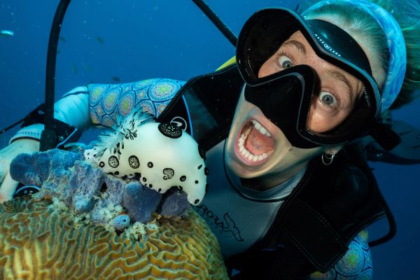 scuba instructor diver with nudibranch on coral