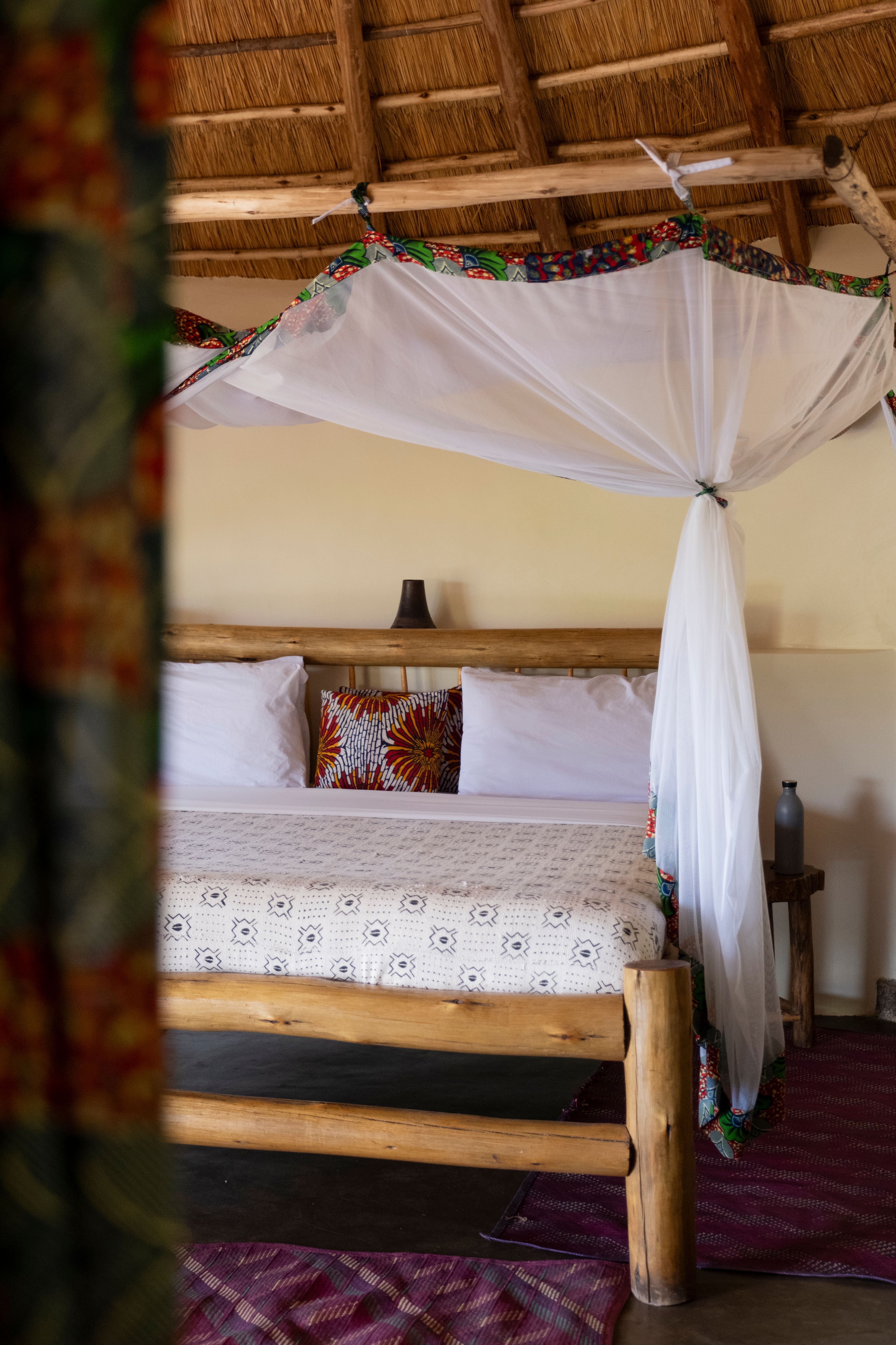 Lit cosy dans un lodge en pleine nature – image chaleureuse pour transmettre confort, détente et expérience d’hébergement.