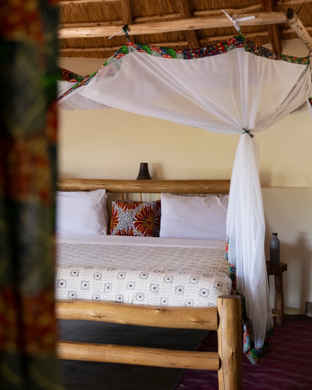 Lit cosy dans un lodge en pleine nature – image chaleureuse pour transmettre confort, détente et expérience d’hébergement.