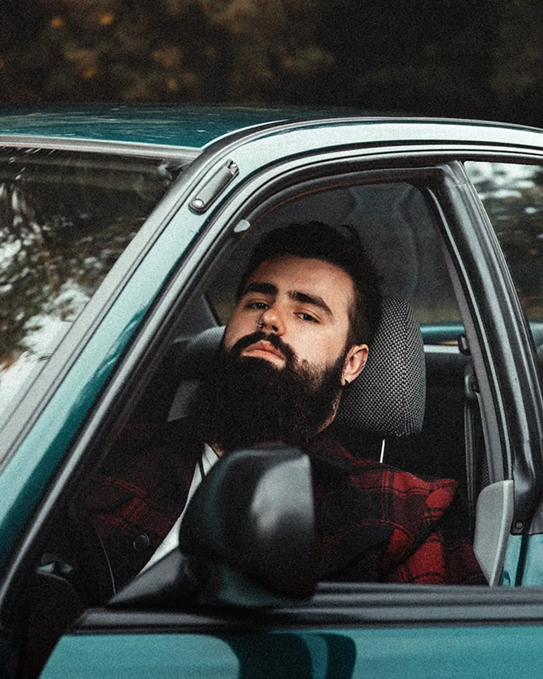 Portrait d’un homme dans une voiture, lumière naturelle et ambiance authentique pour révéler caractère et présence.
