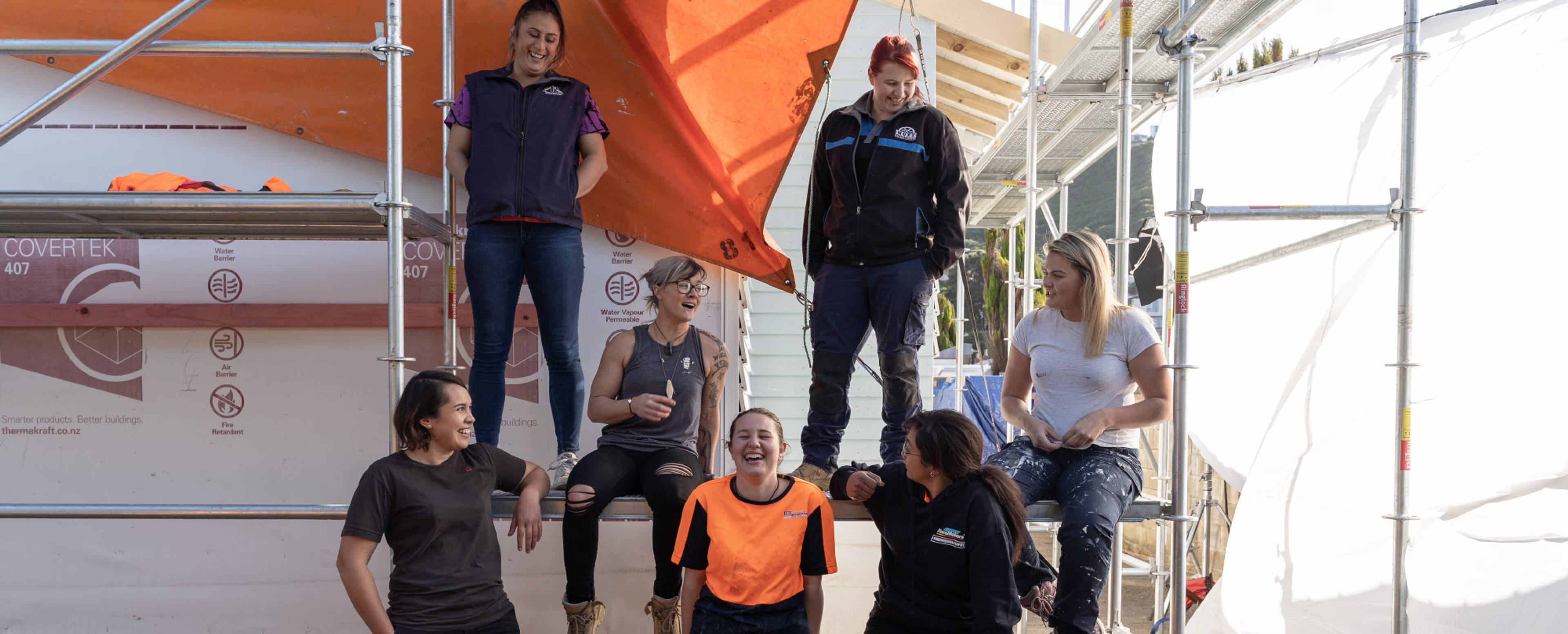  A group of women laughing together on scaffolding 