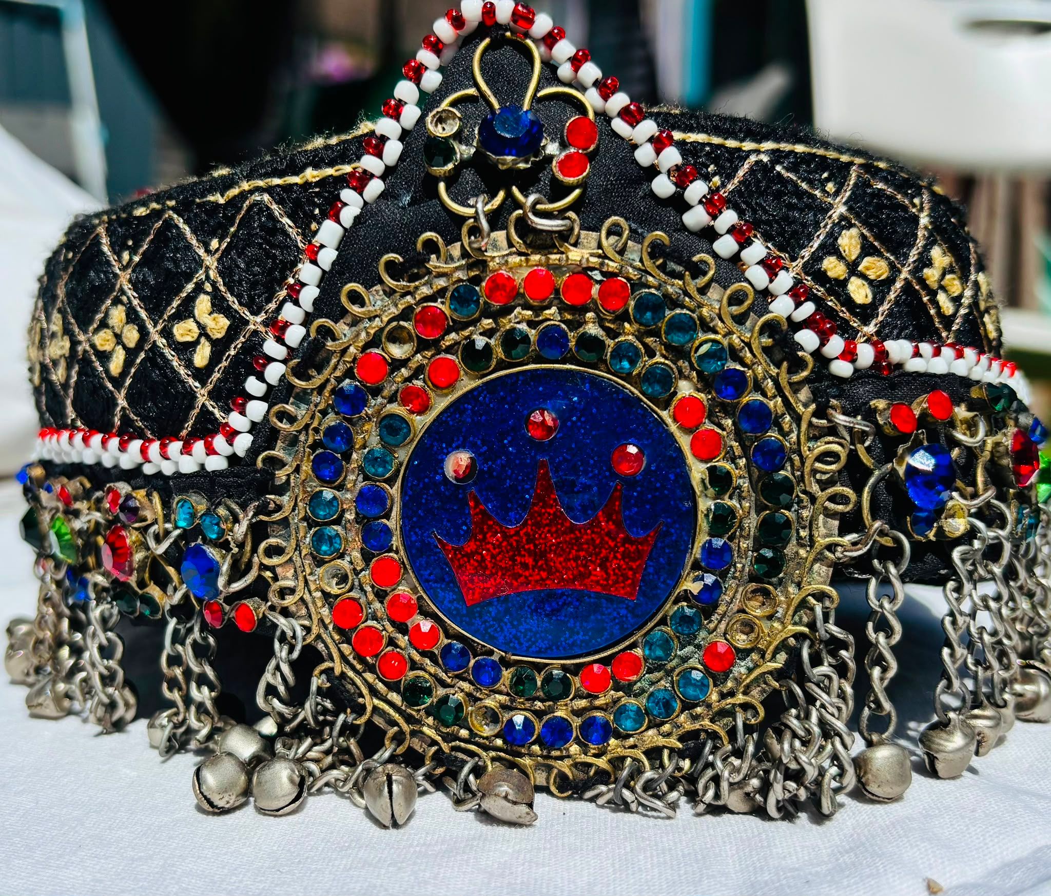 Traditional Afghan headpiece with stones, bells and a crown motif" / Caption: "The headpiece: vibrant stones and bells that jingle at the slightest movement