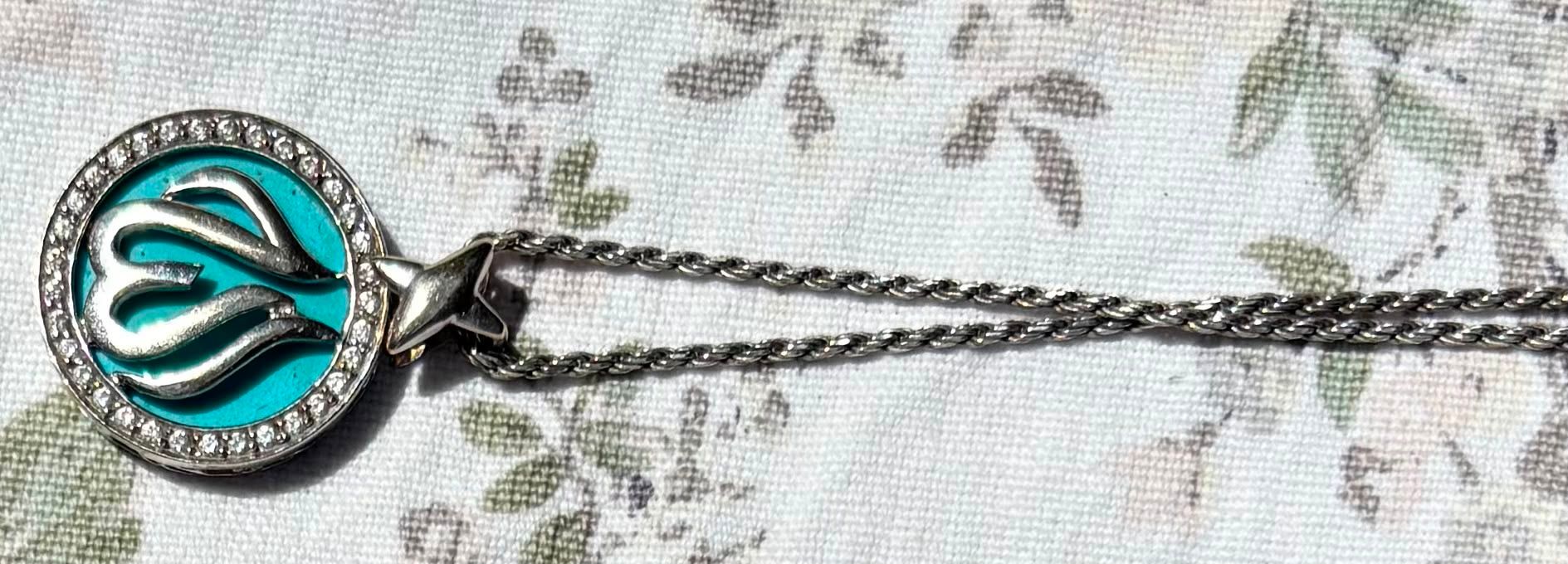 Ferozah turquoise pendant in silver on floral cloth