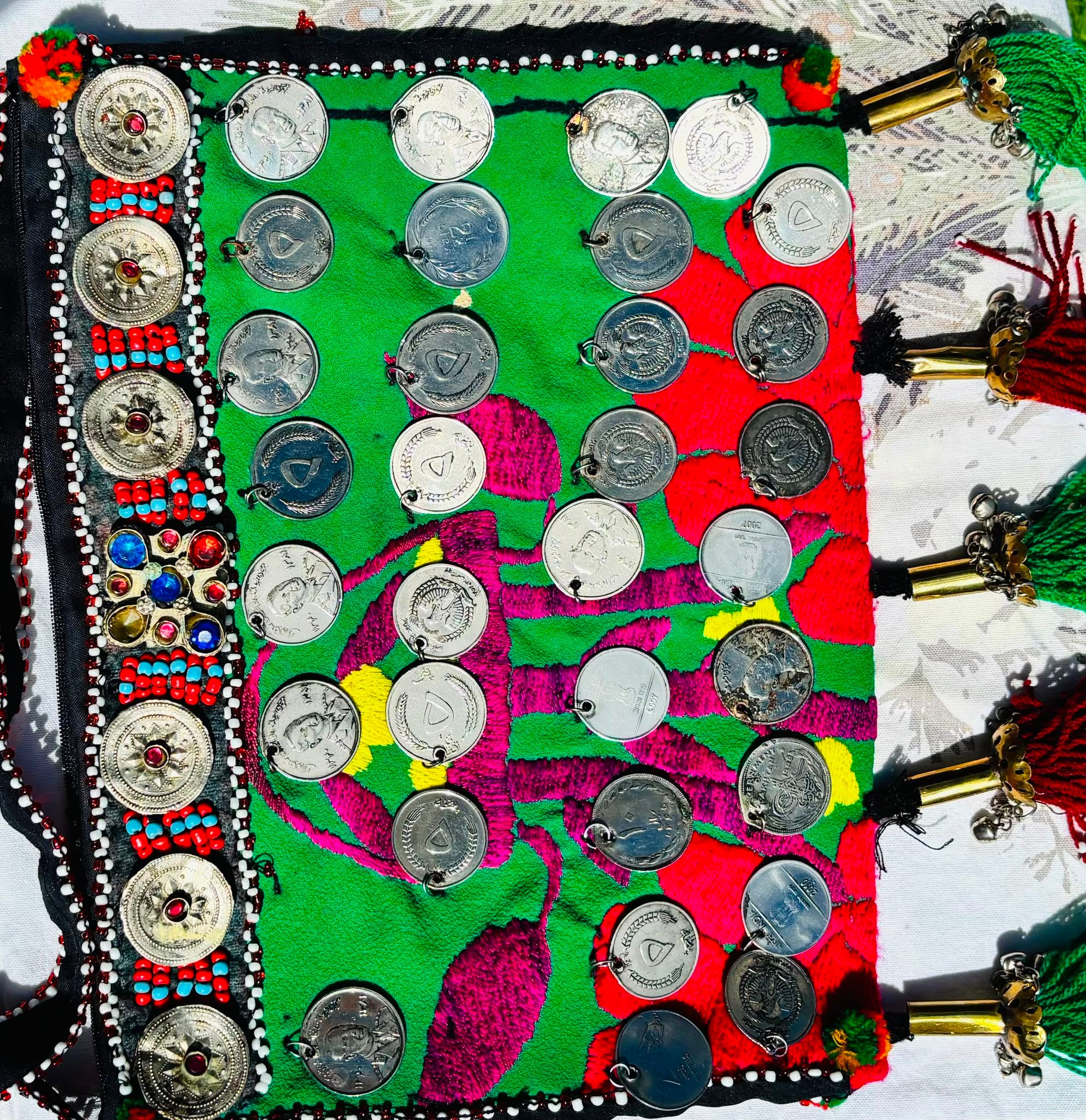 Afghan bag stitched with rows of silver coins" / Caption: "Rows of genuine coins, many bearing Mohammed Zahir Shah, the last king of Afghanistan: with strays from Pakistan, India and, somehow, Canada.