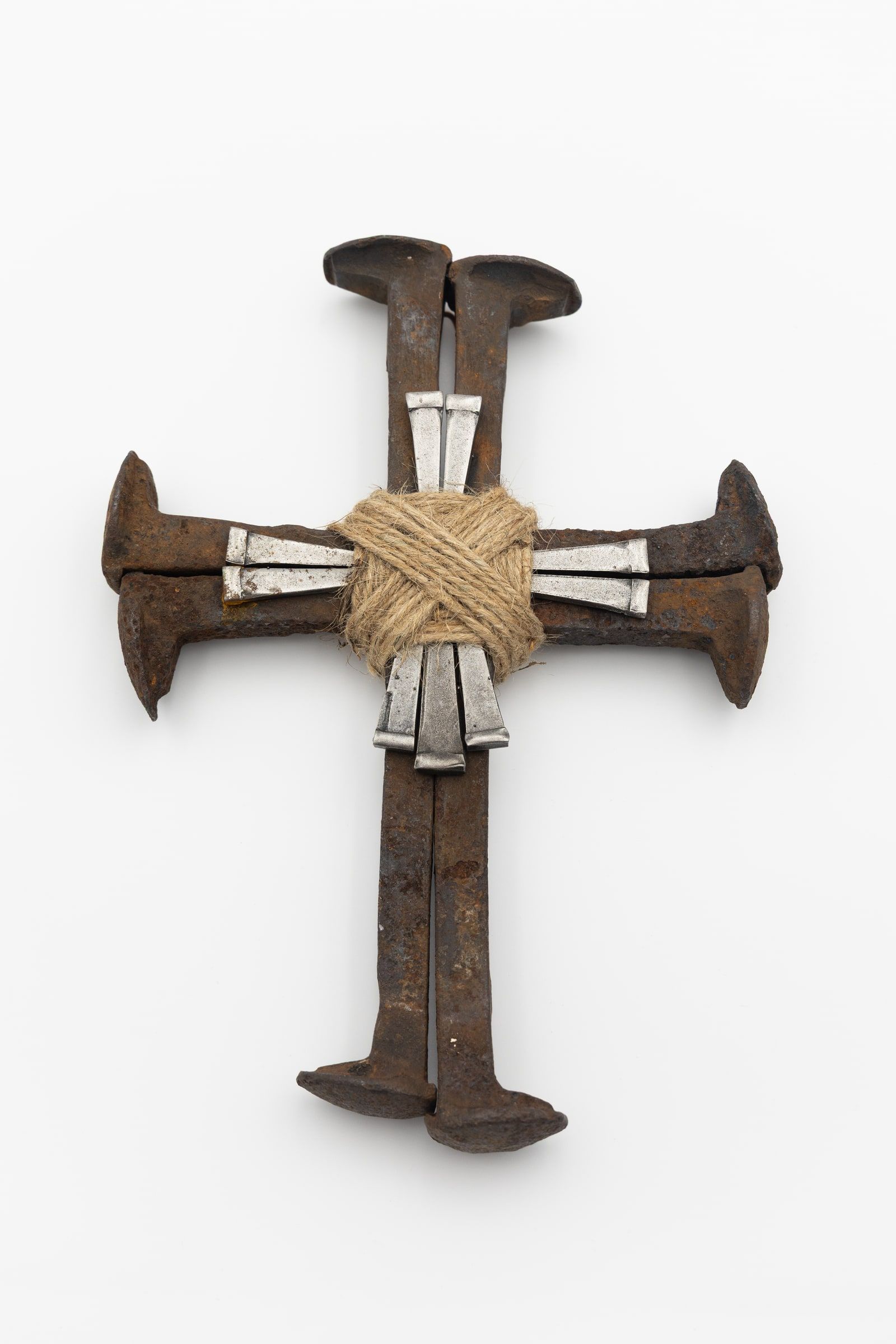 A cross built from railroad spikes, the four arms bound together at the centre with wound silver wire.