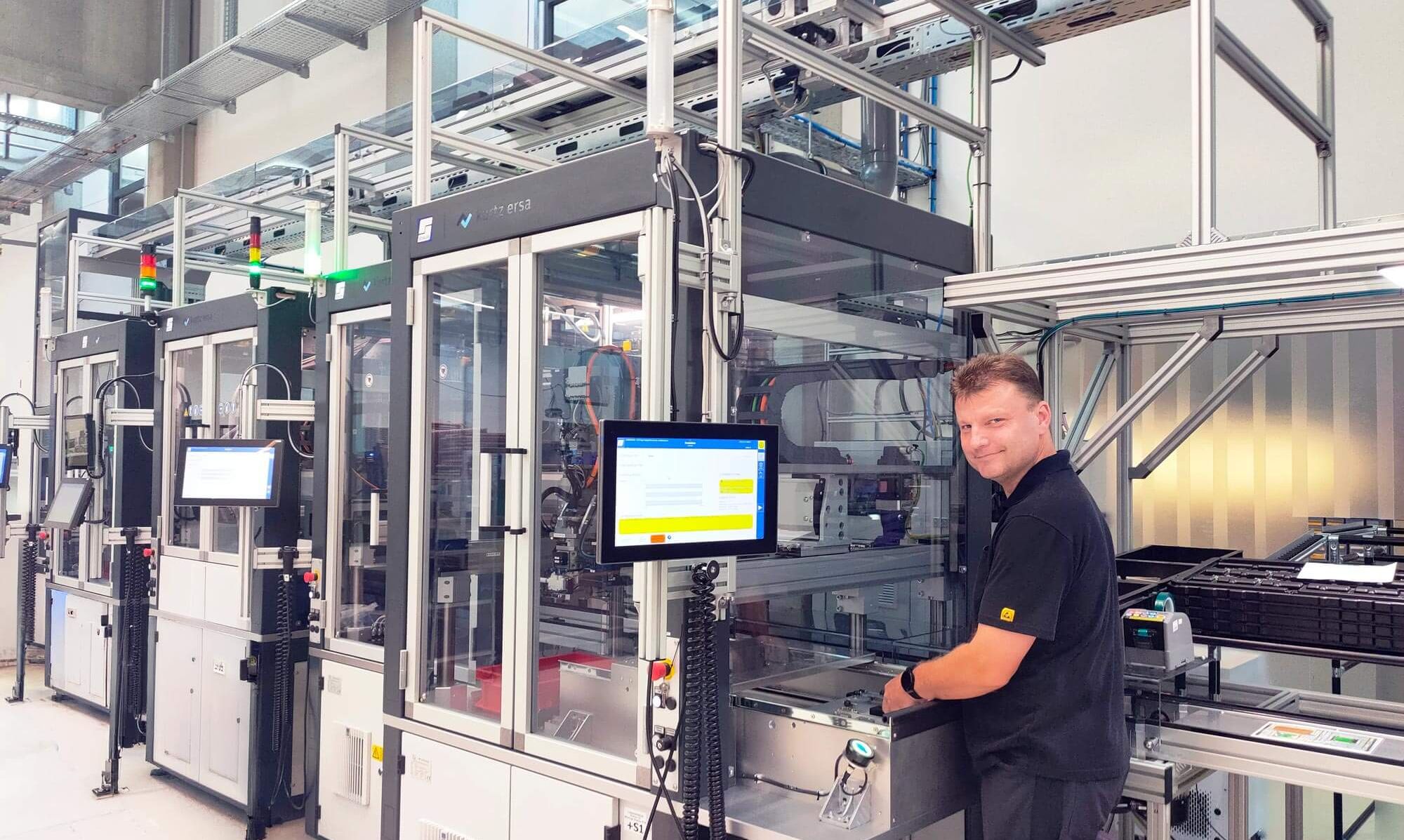 Production hall picture od the HMI Line and an middle aged male employee