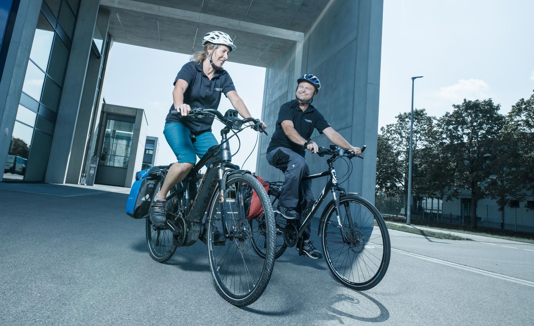 Two women ride off the site on an e-business bike