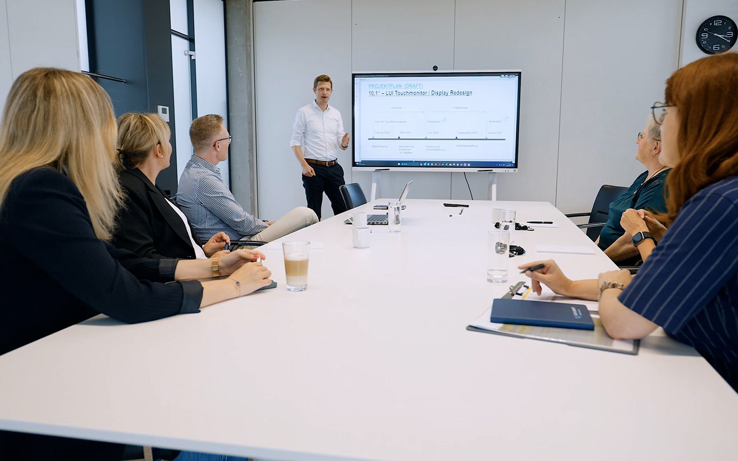 Ein Mitarbeiter schreibt gerade an ein digitales FlipChart