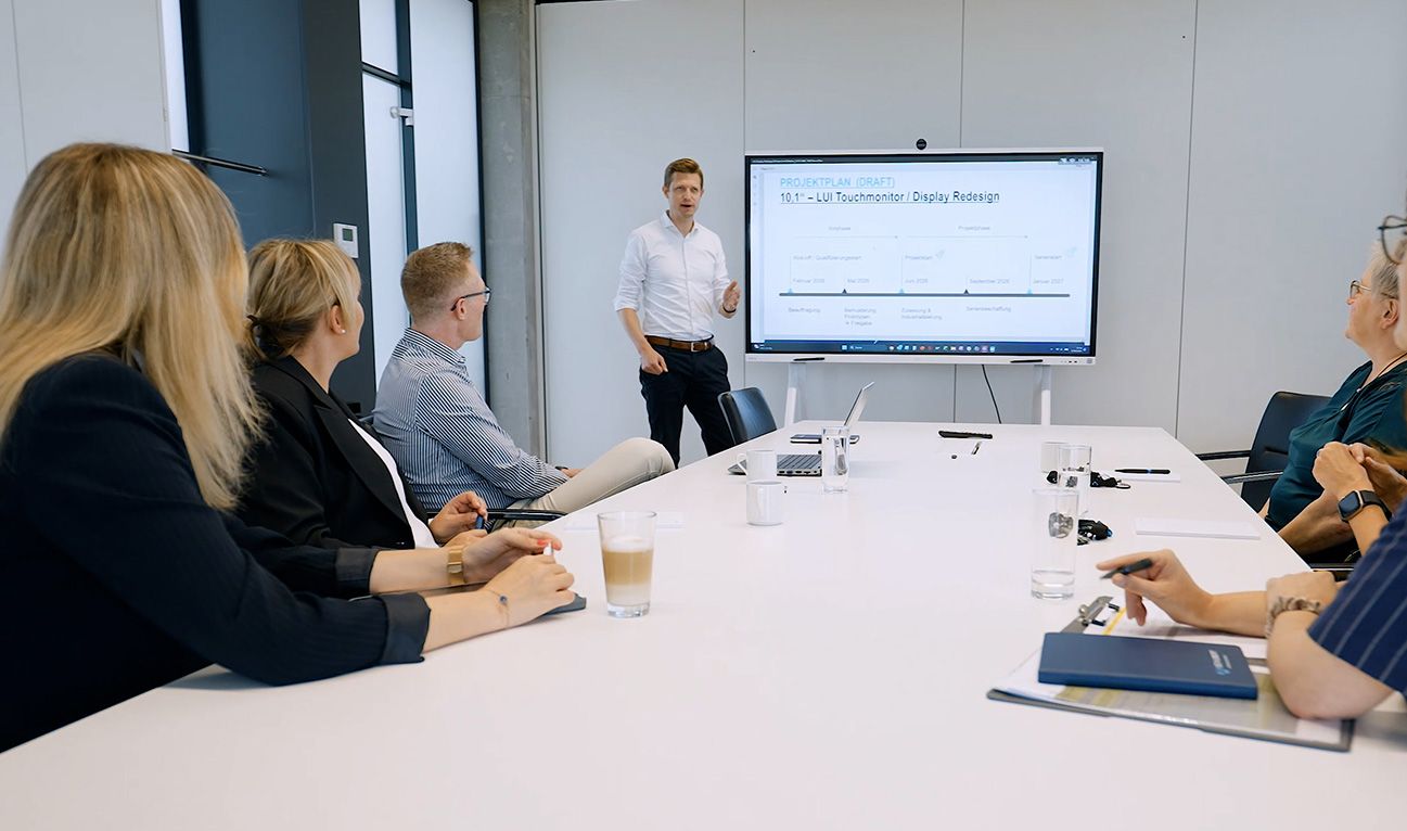 In a lecture situation, an employee informs the participants in the meeting room