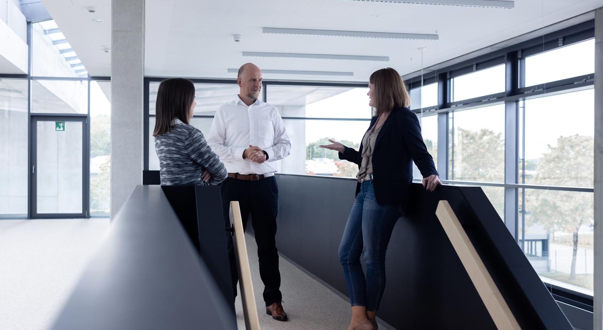 Drei Mitarbeiter in einem Gespräch im Unternehmen. 