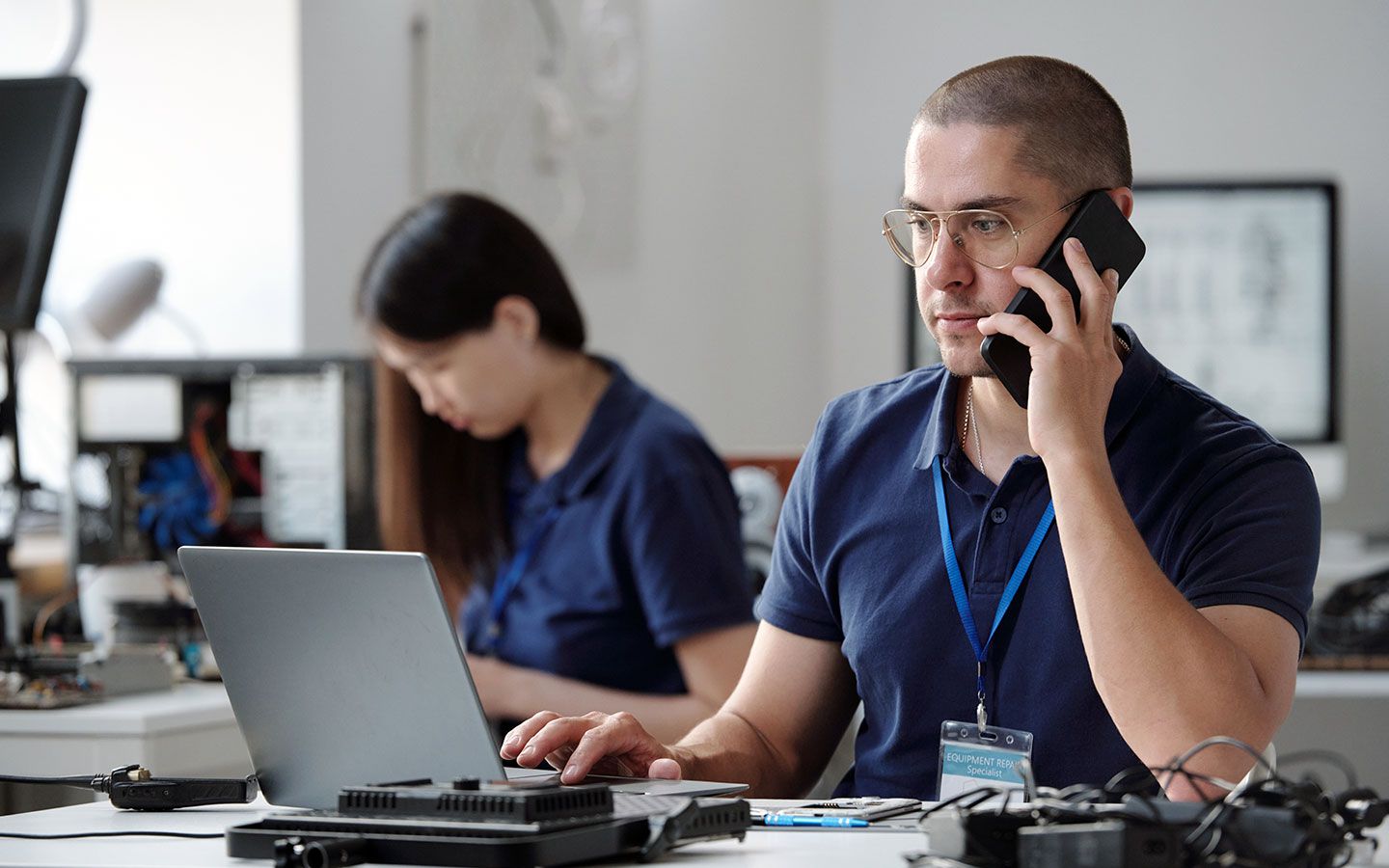 BK Mikro employee at laptop and phone