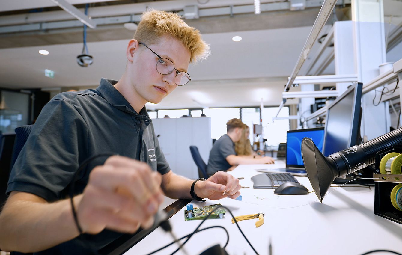 Two trainees in the workplace at soldering