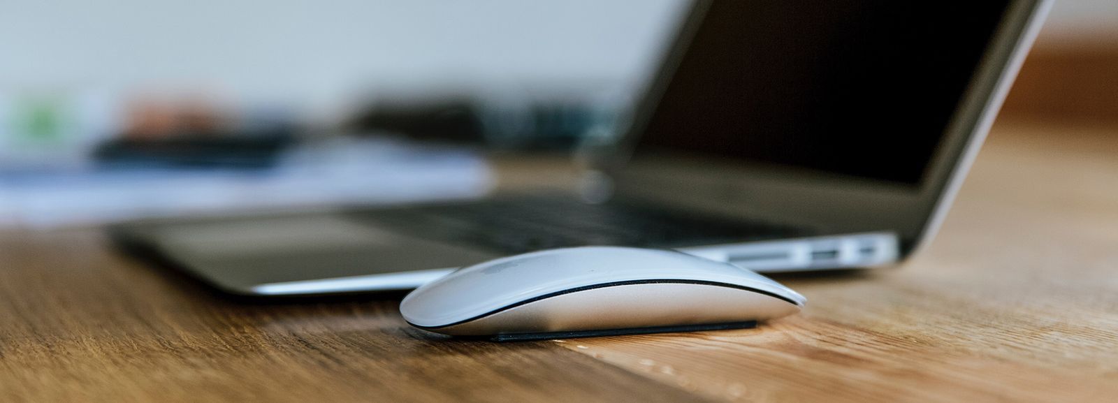 MacBook Air and Apple Magic Mouse on brown wooden table photo