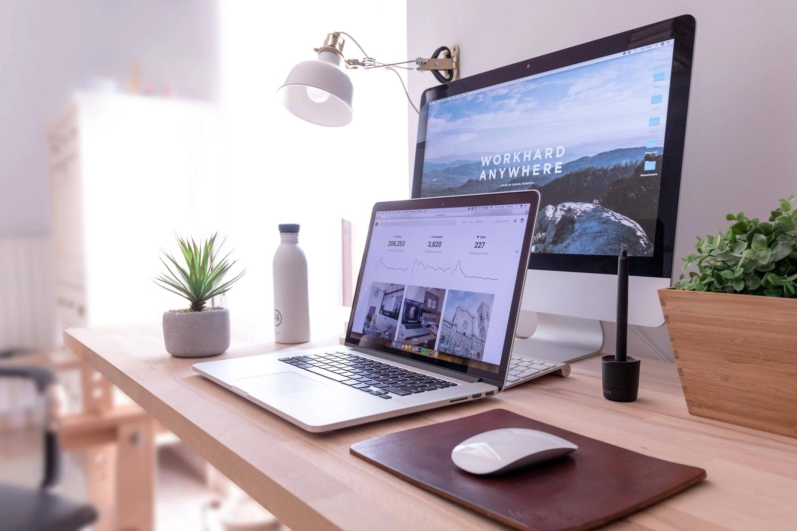 Open MacBook and monitor showing a website.