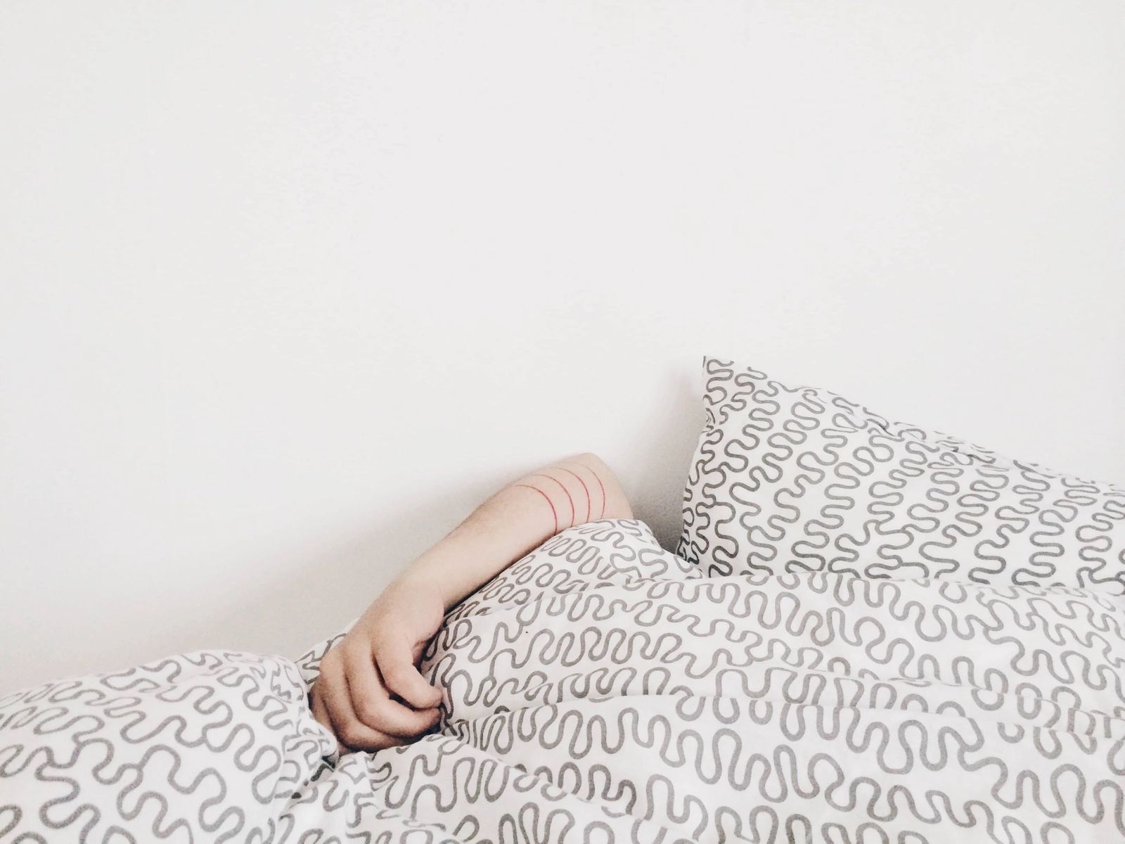 Person lazing under quilt blanket.