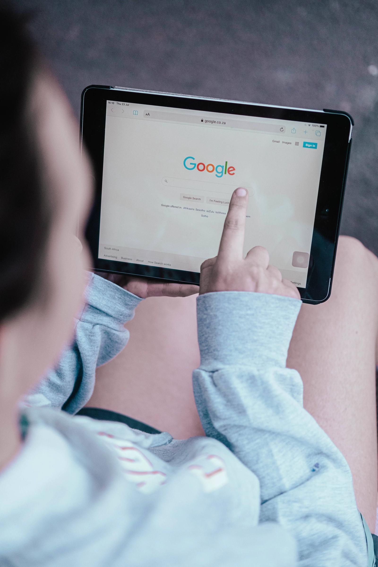 Person using tablet to search on Google