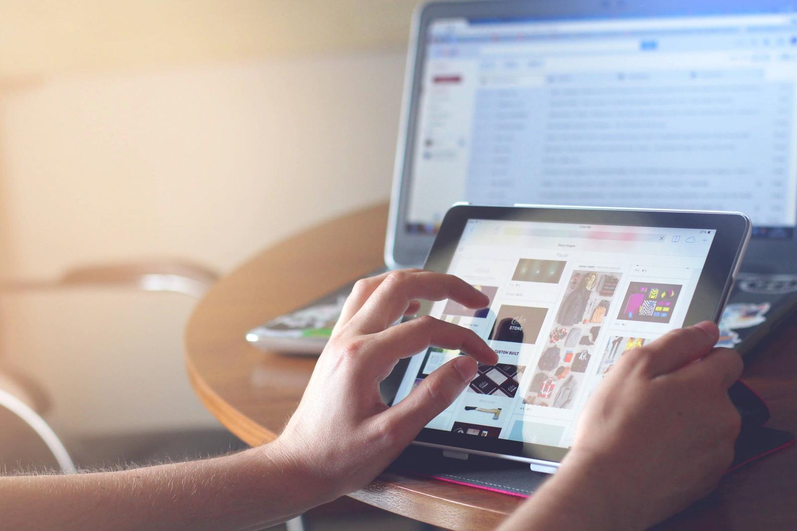 Person holding tablet searching through images.