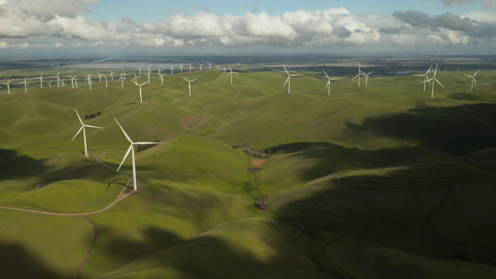 white windmills in open fields during the daytime