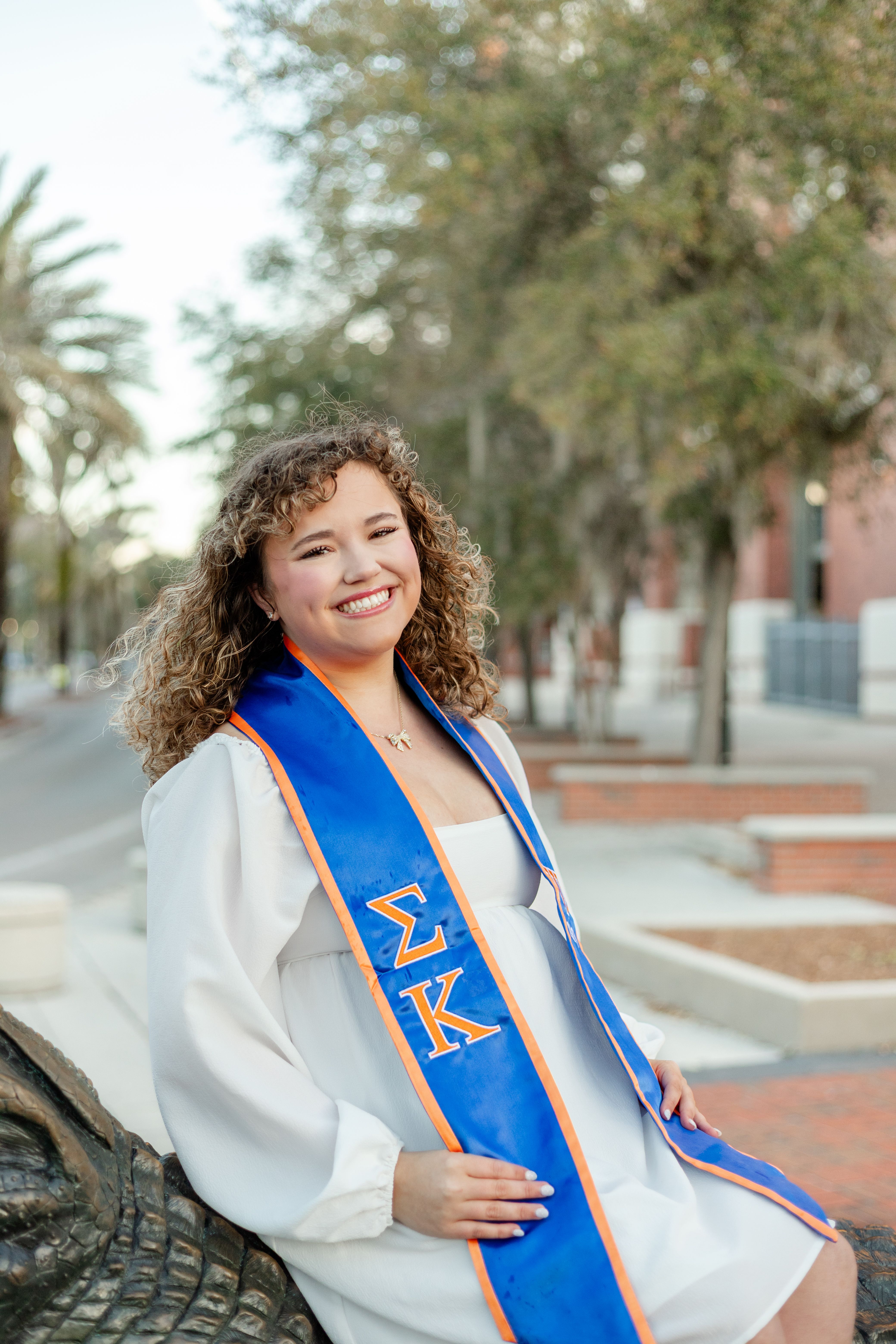 A Florida Gator Grad holding her cap for grad photos at Gator Walk