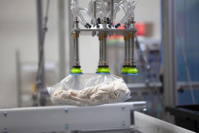 Covariant robot gripper holding polybagged apparel