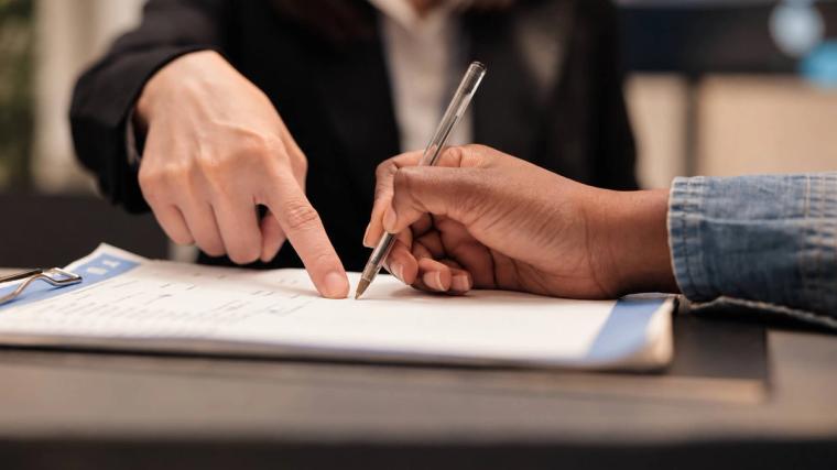 De uitzendkracht tekent het contract op kantoor