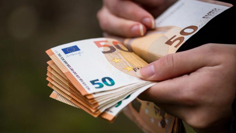 Pracownik liczący banknoty euro, wynagrodzenie i płaca minimalna podczas pracy w Holandii