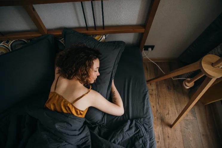 Person deeply asleep, dim bedroom, calm