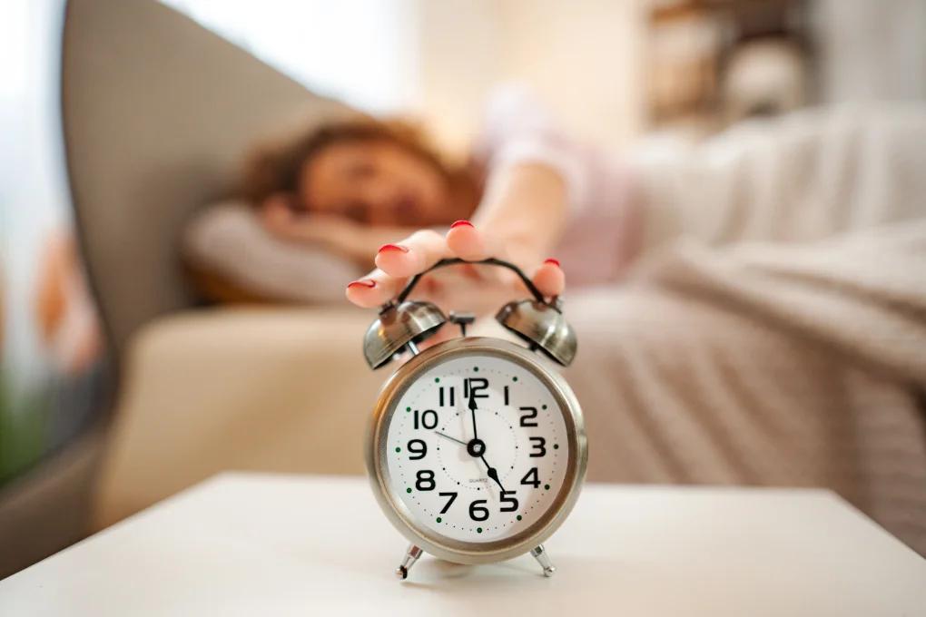 EDITORIAL — person awake in bed at dawn, tired but real, soft light