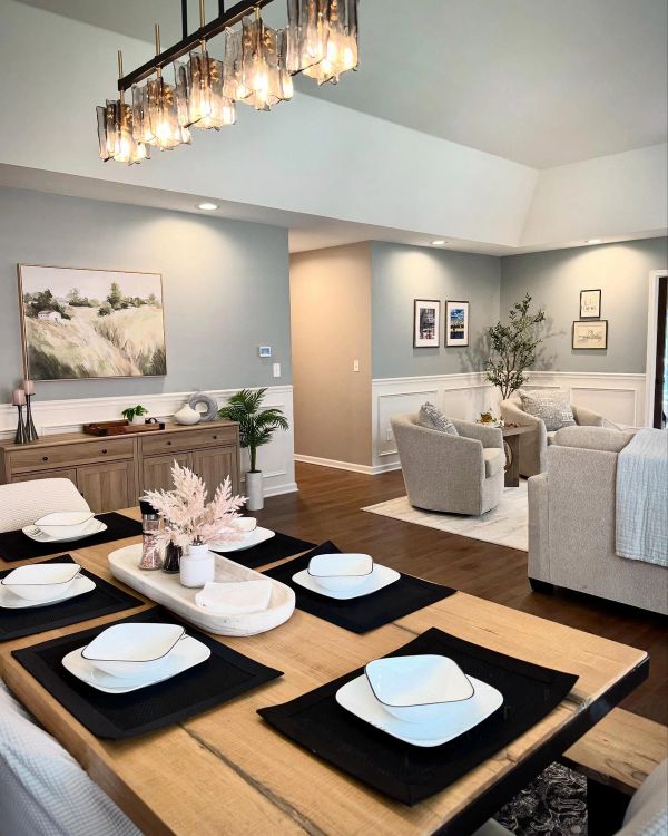 Open-concept living and dining room with applied mouldings and curated lighting