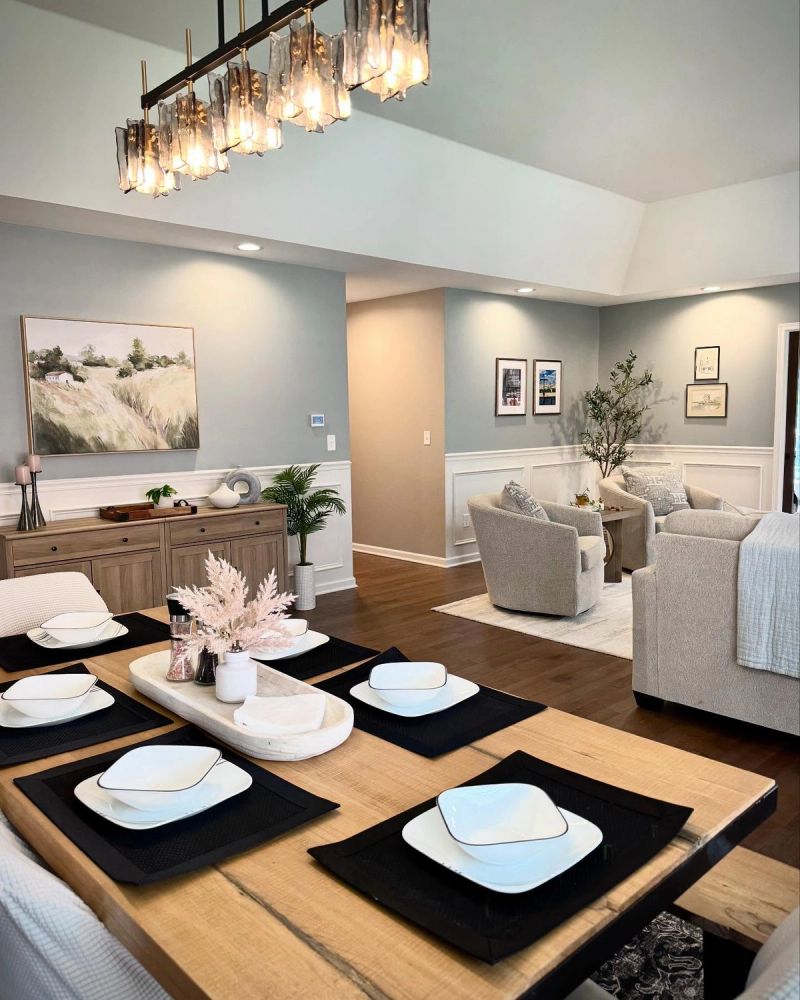 Open-concept living and dining room with applied mouldings and curated lighting