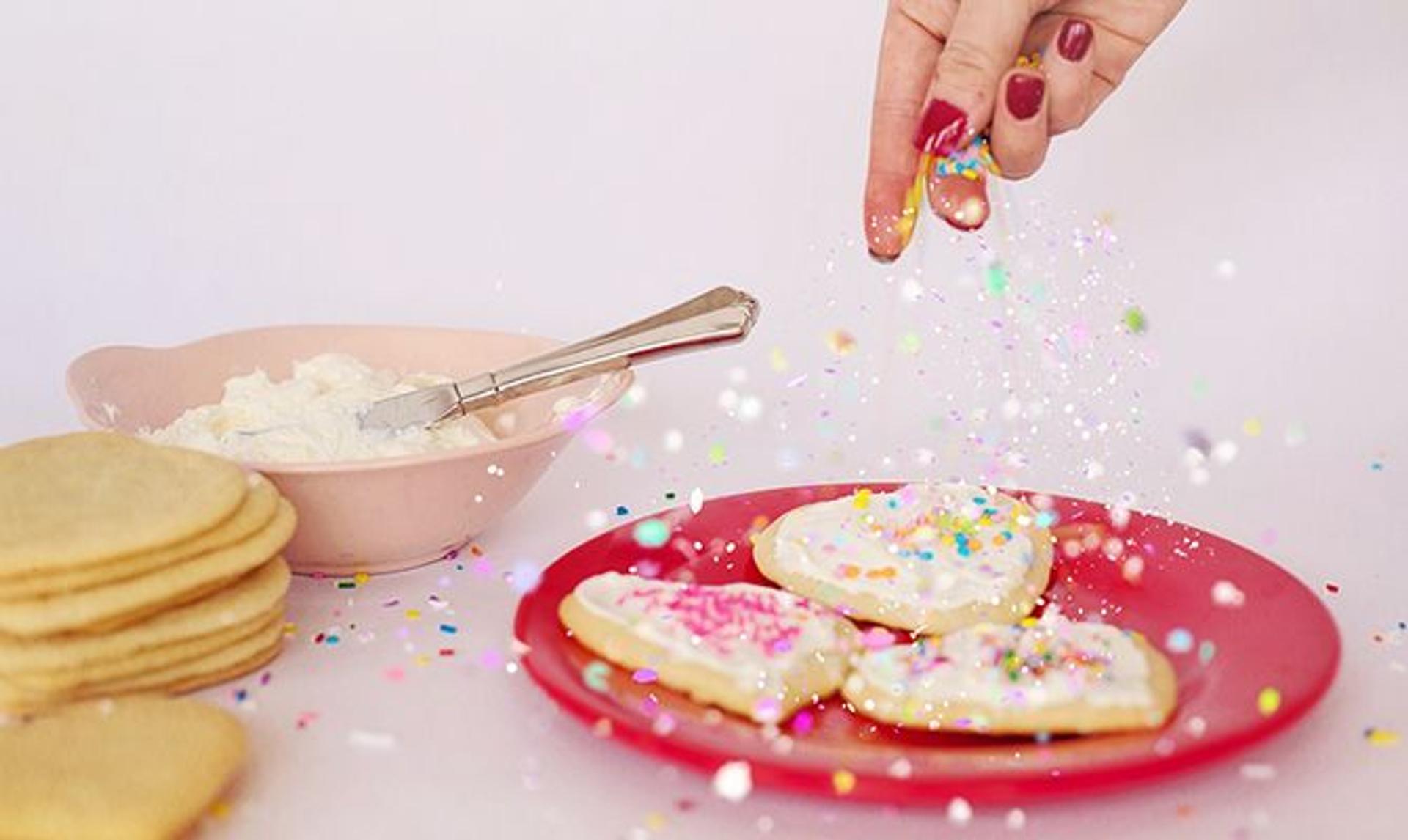 a person is sprinkling sprinkles on a plate of cookies