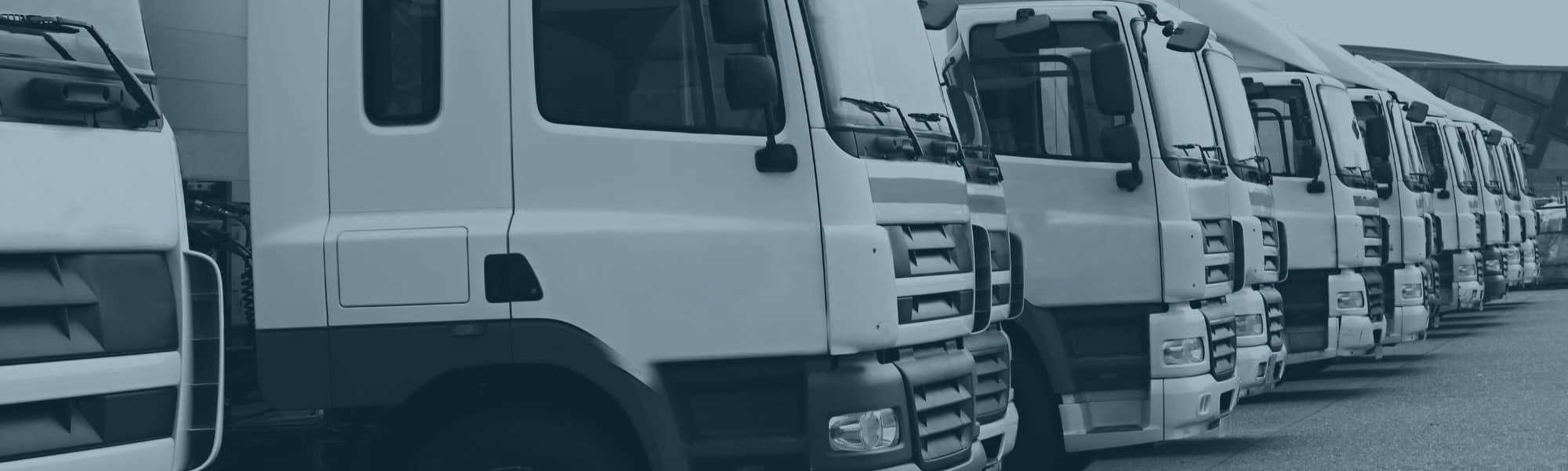Stock photo of a distribution hub with a line up of lorries. Representing a blog post titled "Why the Advance Shipping Notice is vital for retail operations"