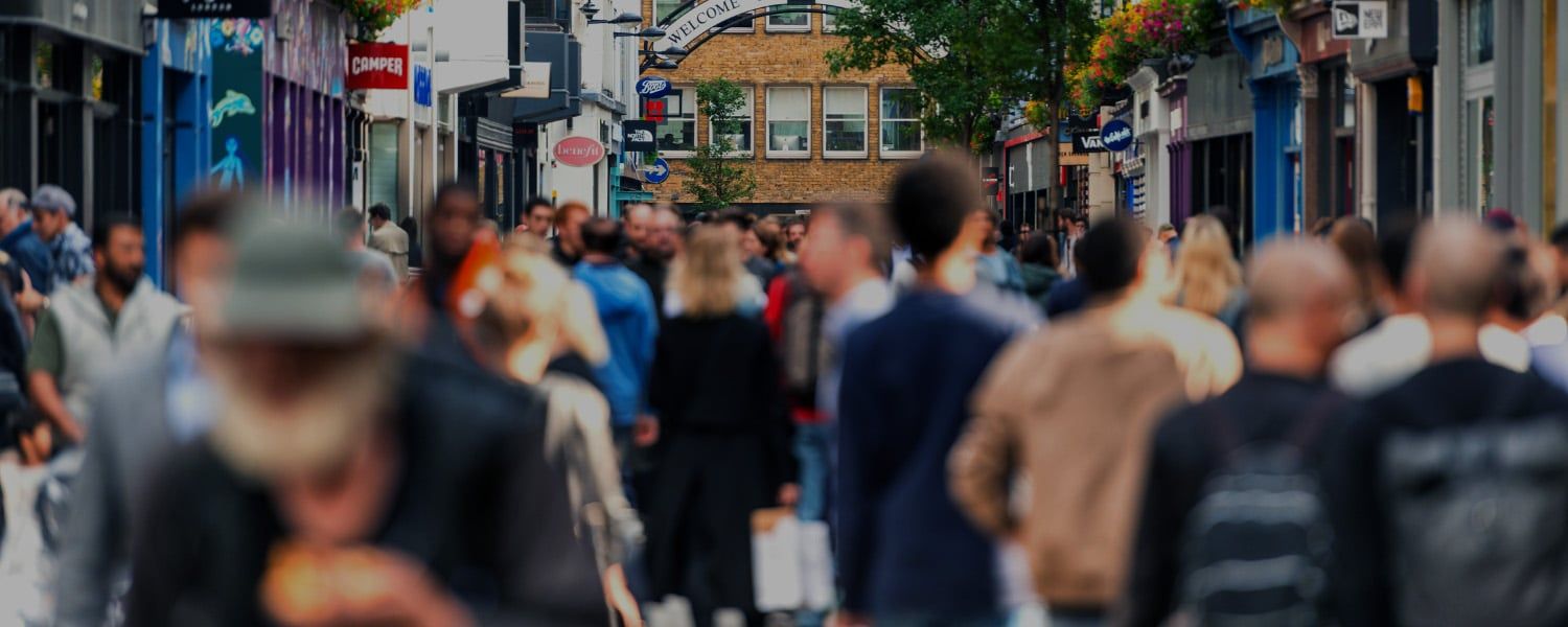 Stock photo of a busy high-street with crowds of people out of focus. Used as the header image of a blog focused on a Transalis client case study for VAT Mandates