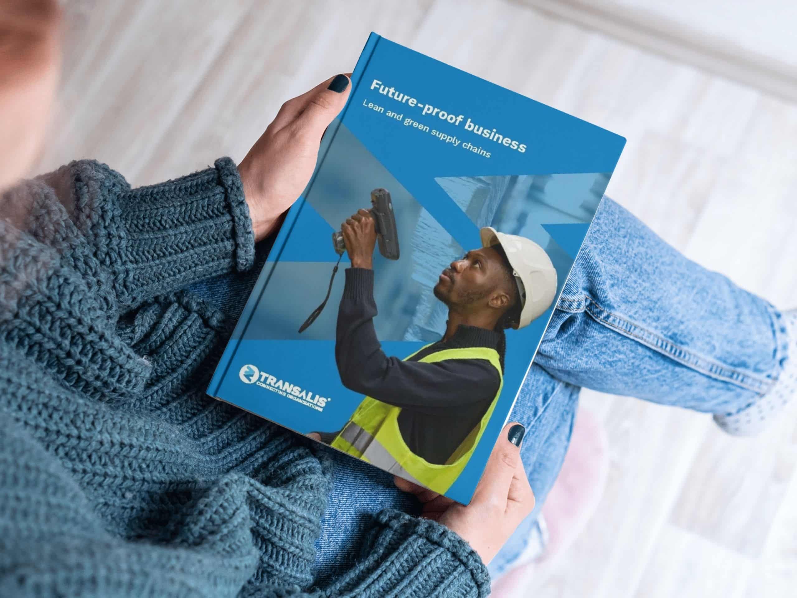 Mockup of the Transalis report 'Build a future-proof business with lean, green supply chain strategies', held by a reader.
