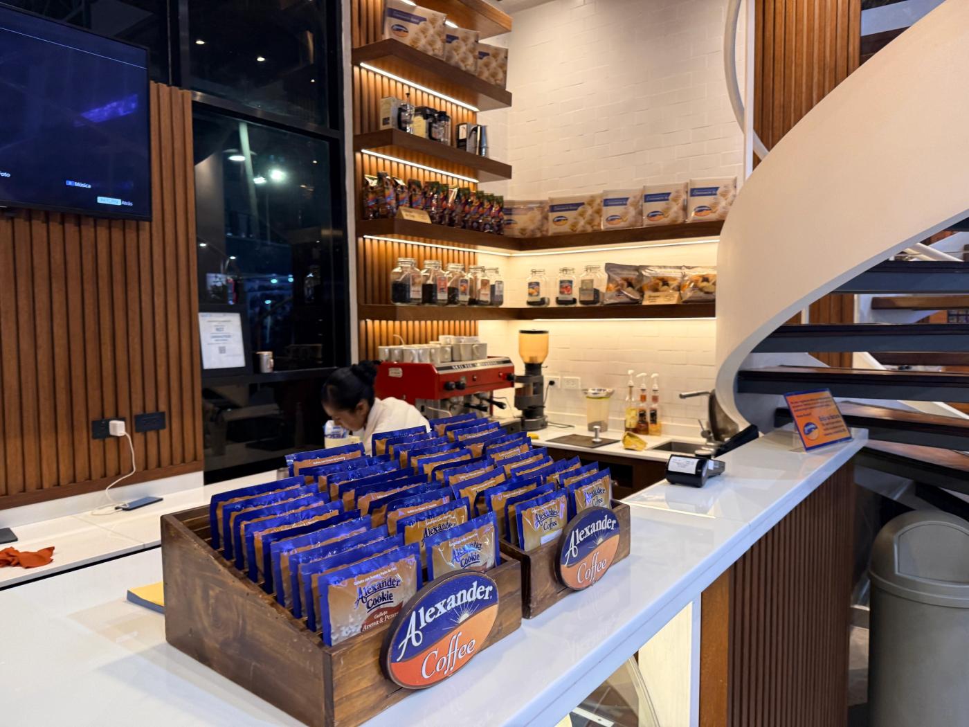 볼리비아 Alexander Coffee 매장 안에 원두와 과자 제품, 에스프레소 머신이 진열된 카운터 모습.
