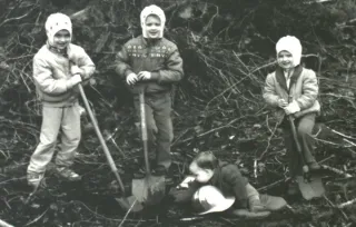 Four children with shovels in an old black-and-white family photo