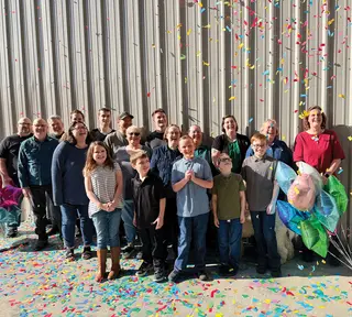 A group of Timberdoodle people celebrates with lots of confetti