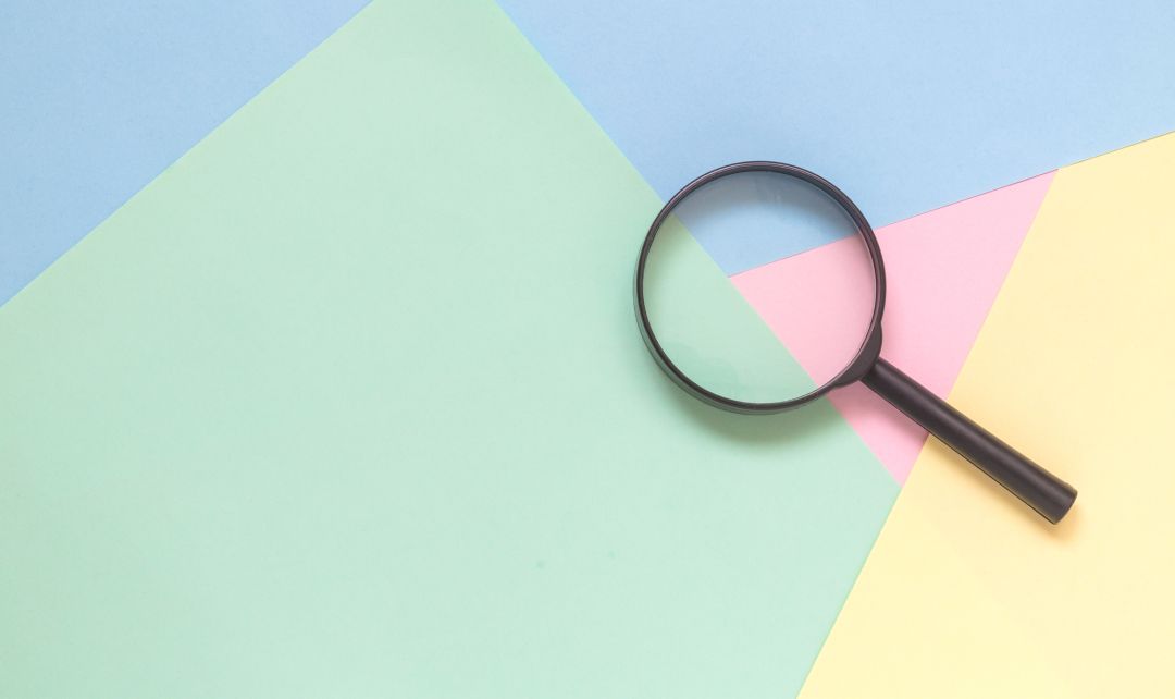 Magnifying glass on a colourful background