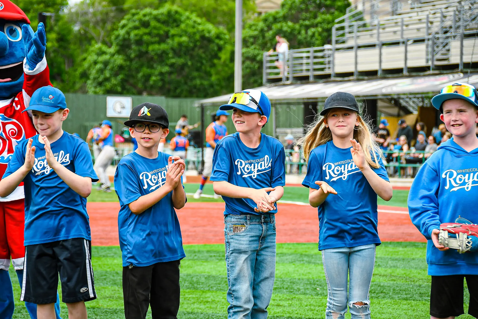 kids lined up on baseball field in team uniforms