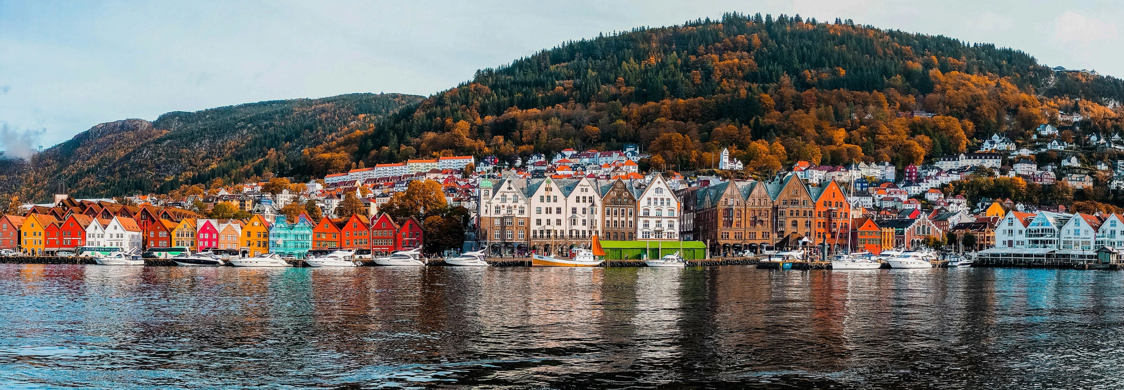Bryggen i Bergen sett fra Vågen, med Fløyen i høstfarger i bakgrunnen