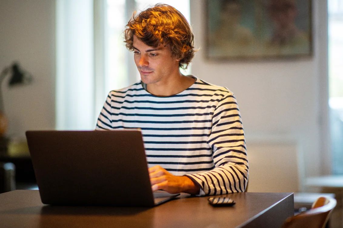 Ingeniør i stripete genser jobber på en bærbar PC